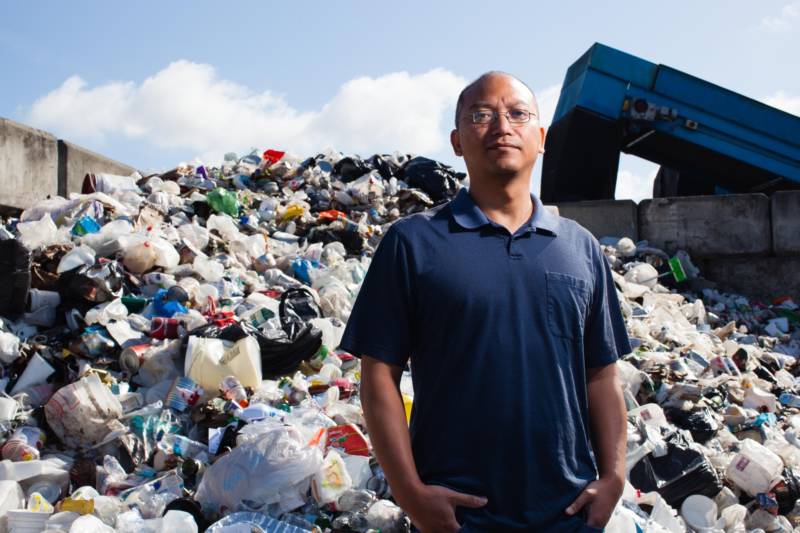 Daniel Maher stands in front of a pile of recycling at the Berkeley Ecology Center.