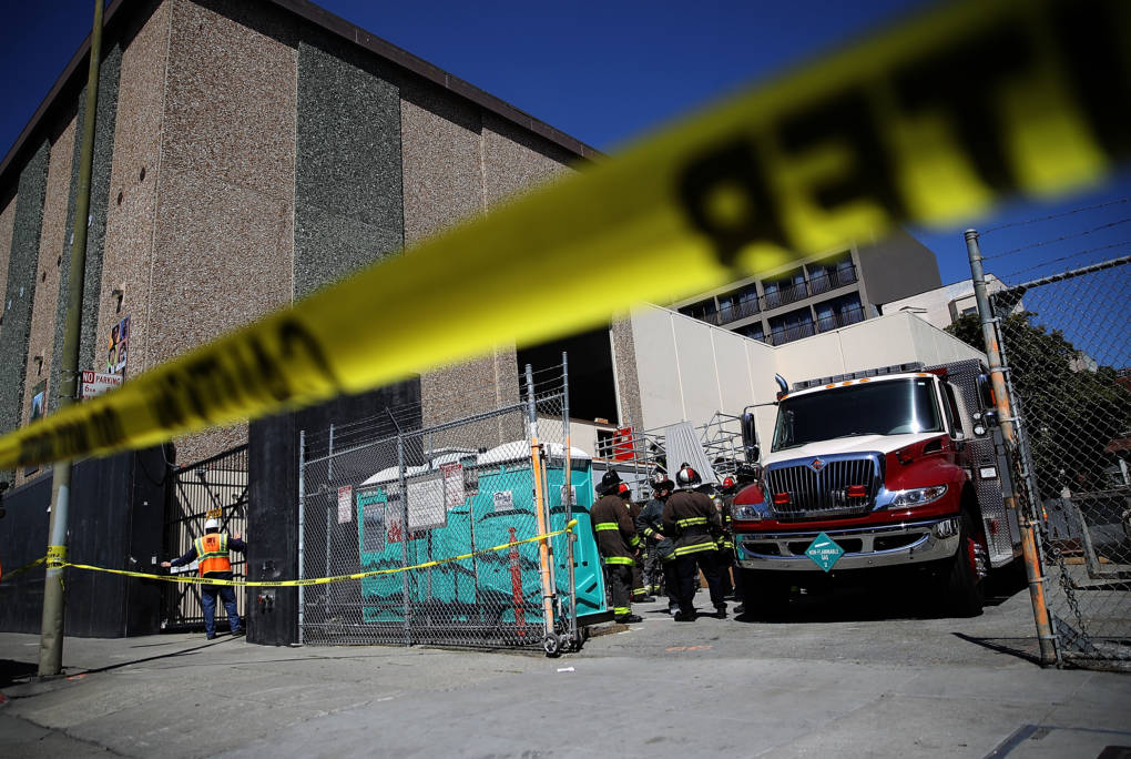 San Francisco fire department crews stand outside of an electric substation where a fire occurred and might have caused the outage.