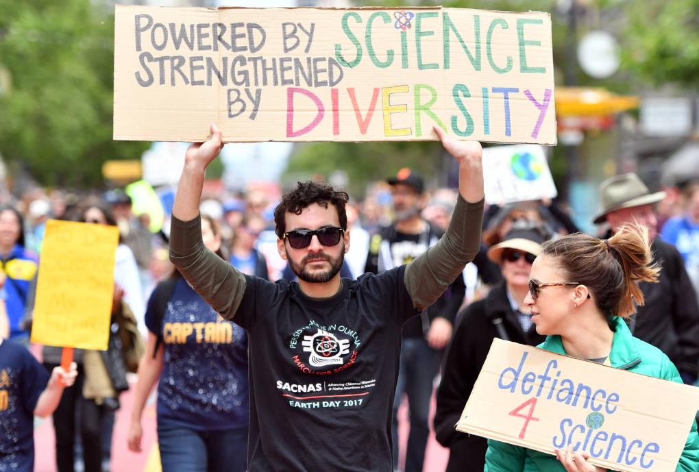 Raul Tores (C) holds up a sign during the March for Science in San Francisco, 