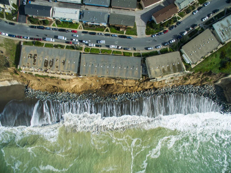 Apartment buildings hang perilously over an increasingly eroded bluff in Pacifica.