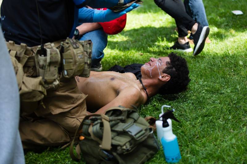 A volunteer medic washes a protester's face with milk after he was exposed to pepper spray on April 15, 2017. Berkeley police arrested at least 21 people during a pro-Trump rally that became violent after counter-protesters clashed with demonstrators.