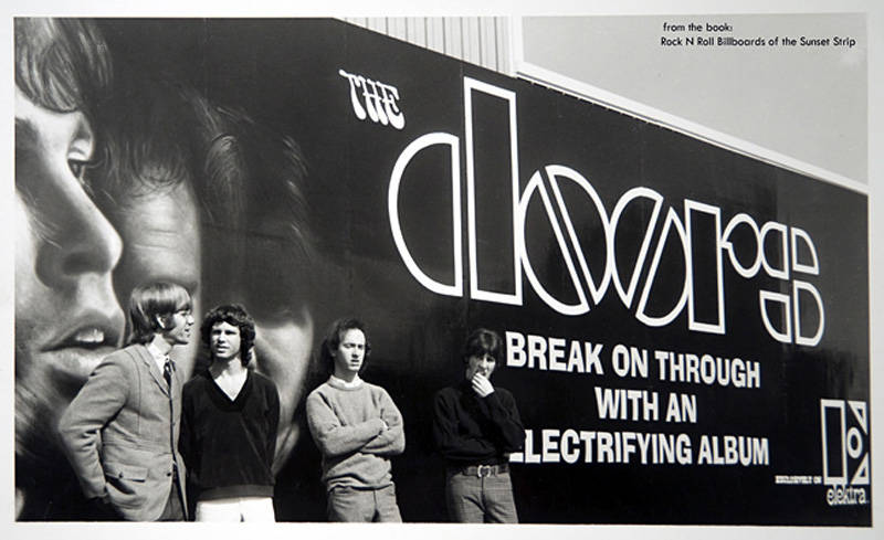 The Doors band members pose in front of their billboard for their debut album at Foster and Kleiser studios in Los Angeles.