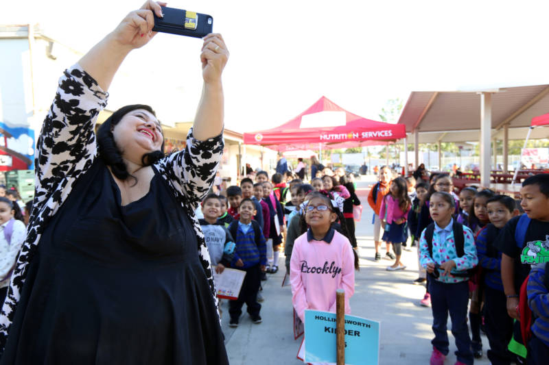 Madison Elementary School Principal Lisa Gonzales-Solomon snaps a selfie with her students one morning before class in Santa Ana. The district is one of 15 CALmatters studied to understand how well the state’s new school funding formula is working.