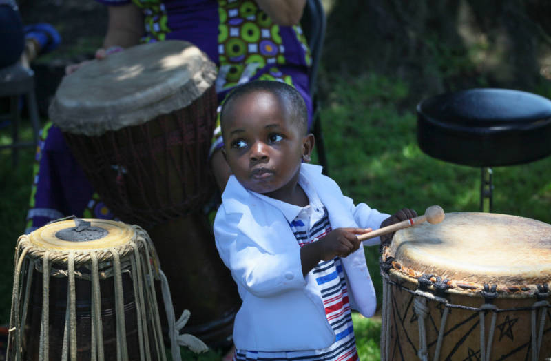 Mazani Ali, age 2, takes to the drums at a picnic in San Diego, home to the state’s largest cluster of refugees.