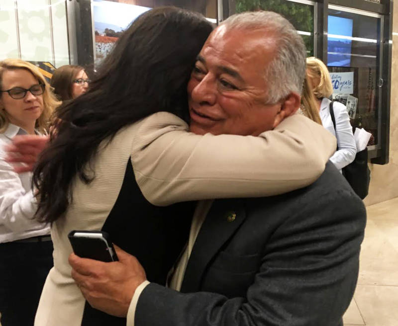 GOP Assemblyman Rocky Chavez gets a congratulatory hug after his vote to back cap-and-trade’s reauthorization.