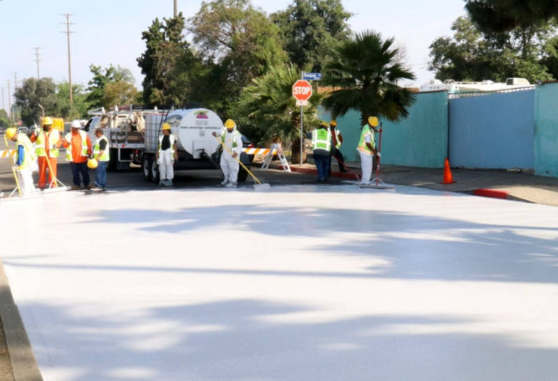 City employees paint a section of Beachy Ave in Pacoima a light gray on June 3, 2017 as part of a pilot project to test out 'cool pavement.' 