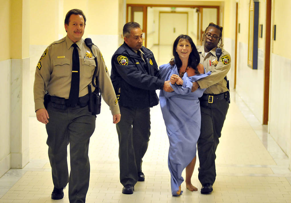 Gypsy Taub who disrobed inside City Hall during a meeting is escorted away on November 20, 2012 in San Francisco.