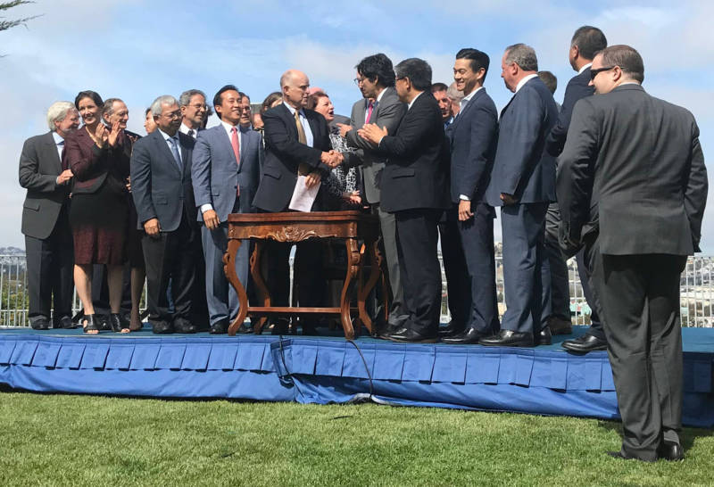Gov. Jerry Brown stands with state lawmakers in San Francisco after signing a package of housing legislation on Friday, Sept. 29, 2017.