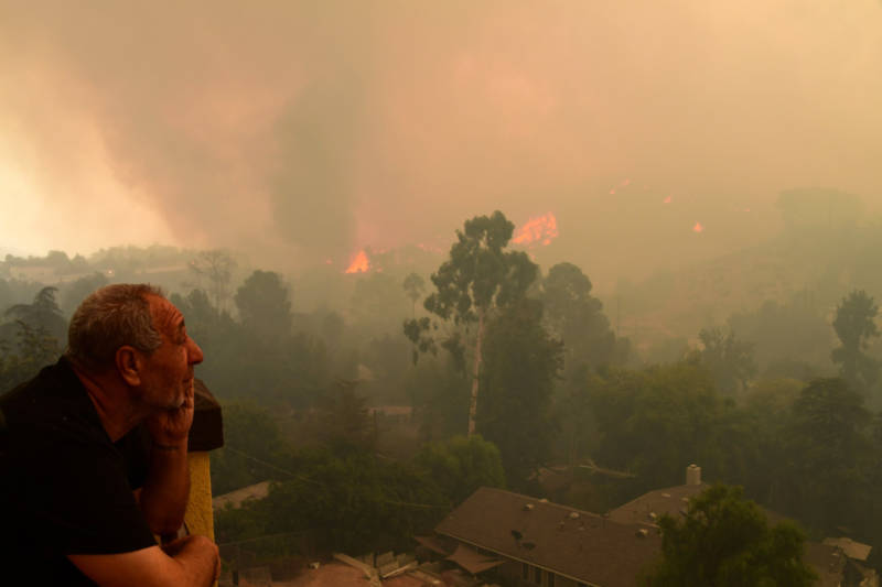 Local resident Ruben Garibyan watches the approach of flames from the La Tuna Fire from his balcony in the Shadow Hills neighborhood of Los Angeles on Sept. 2, 2017.