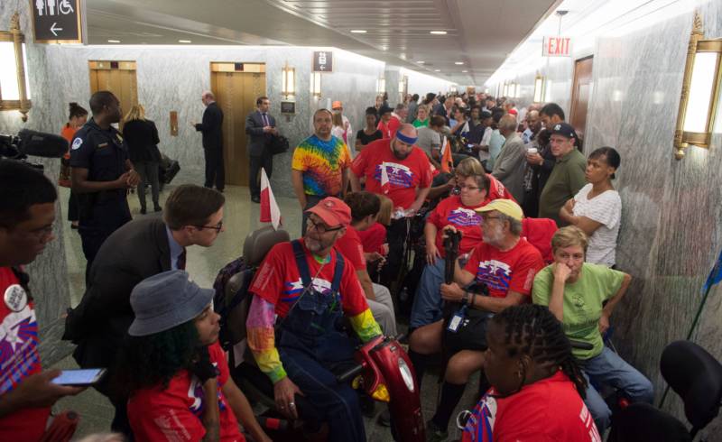Activists and members of the public wait for a Senate Committee on Finance hearing on the latest GOP health care proposal on Capitol Hill on Monday. Once inside the hearing, activists began chanting and temporarily suspended the hearing.