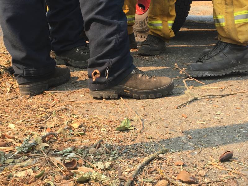 Firefighters create fire lines by cutting down to bare earth and then lighting smaller fires to burn back towards the wildfire, away from buildings and people.