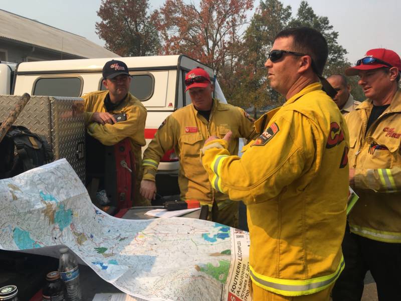A group of firefighters discuss an attack plan for the Nuns fire at the Glen Ellen fire station. 