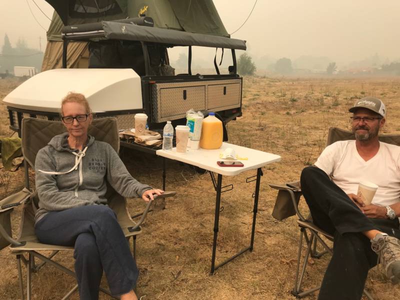 Meg and Jeff Nyholm pitch a tent at the corner of Old Redwood Hwy. and Airport Blvd. They've been sleeping in it since evacuating their home on Monday morning.