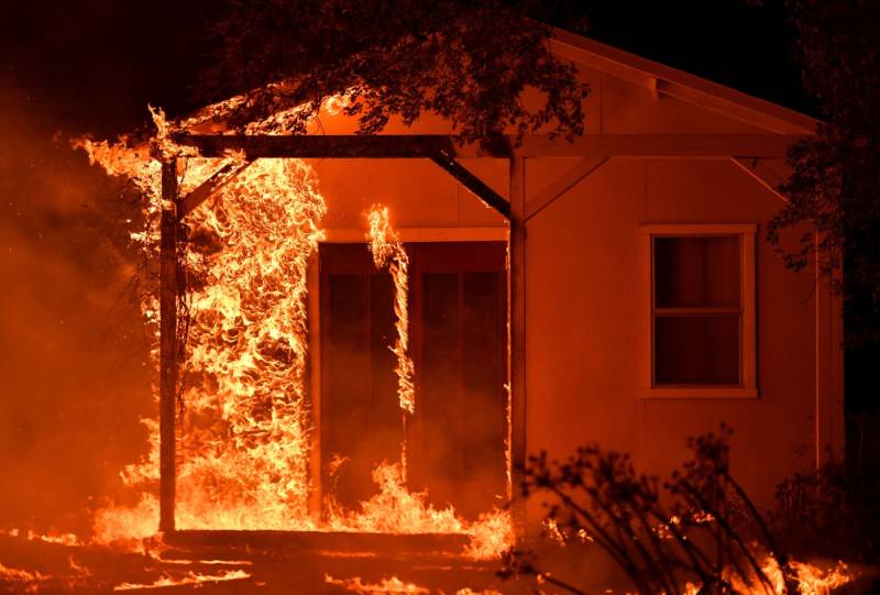Flames overtake a structure as nearby homes burn in the Napa wine region in California on October 9, 2017, as multiple wind-driven fires continue to whip through the region.
