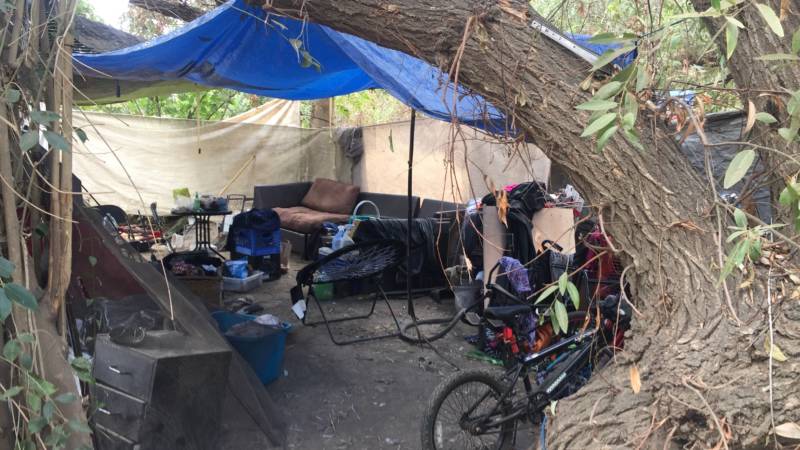 A bike, sofa and other belongings are stored in this makeshift shelter.