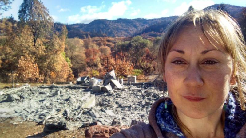 Elly Diaz in front of the ashes that remain of their family home in Redwood Valley, Mendocino. 