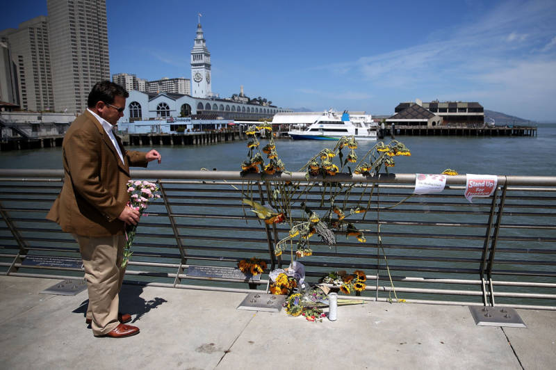 A well-wisher drops off flowers at the site where 32-year-old Kathryn Steinle was killed on July 6, 2015 in San Francisco.