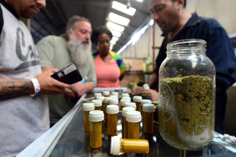 A customer prepares to buy marijuana from a cannabis farmers market in L.A.