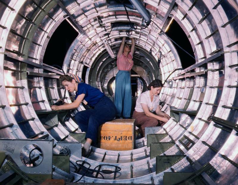 WWII woman workers assemble fuselage of Douglas airplane