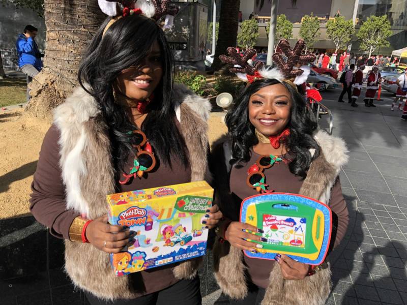 Mattia Edwards and Jessica Gaines show off the toys they plan to donate at San Francisco's Union Square for SantaCon 2017. Edwards called the event, "Christmas for adults."