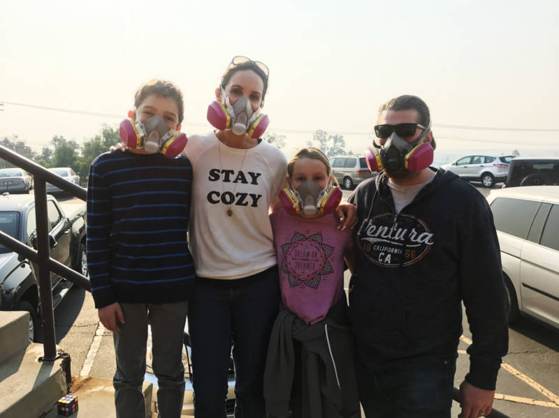 Nancy and Jay Blomquist stand outside the Local Assistance Center in Ventura, with their twins, Alexander and Olivia. The family wears masks to protect themselves from the ash and smoke in the air from the Thomas Fire.