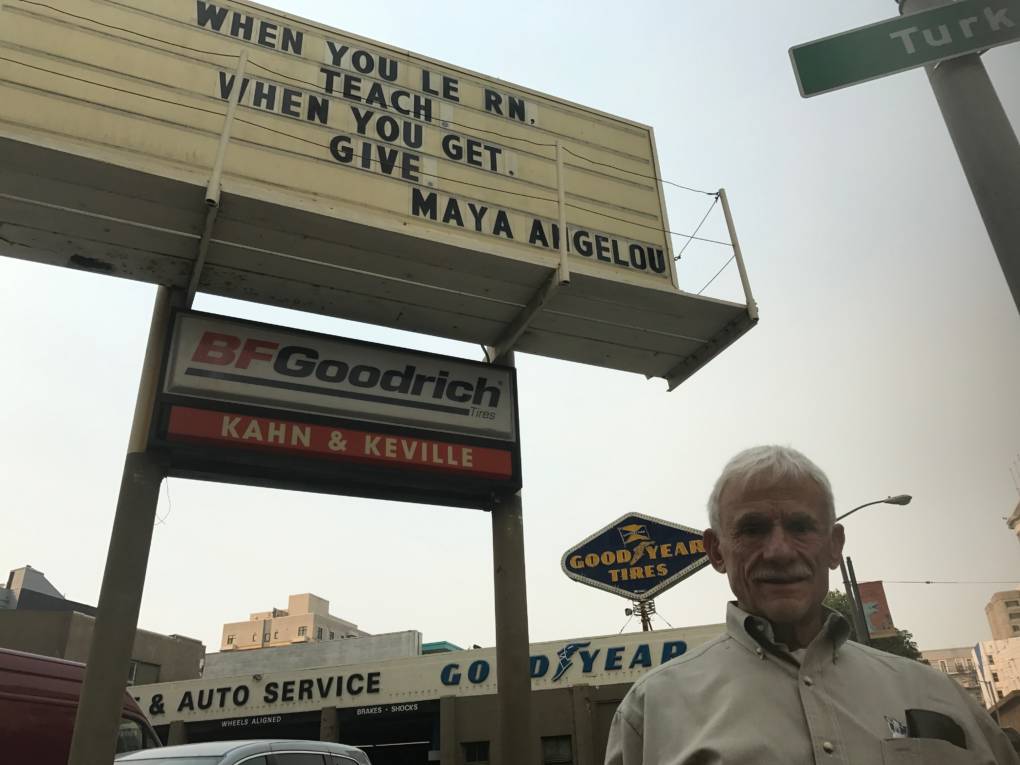 Bill Brinnon in front of the Khan and Keville's sign.