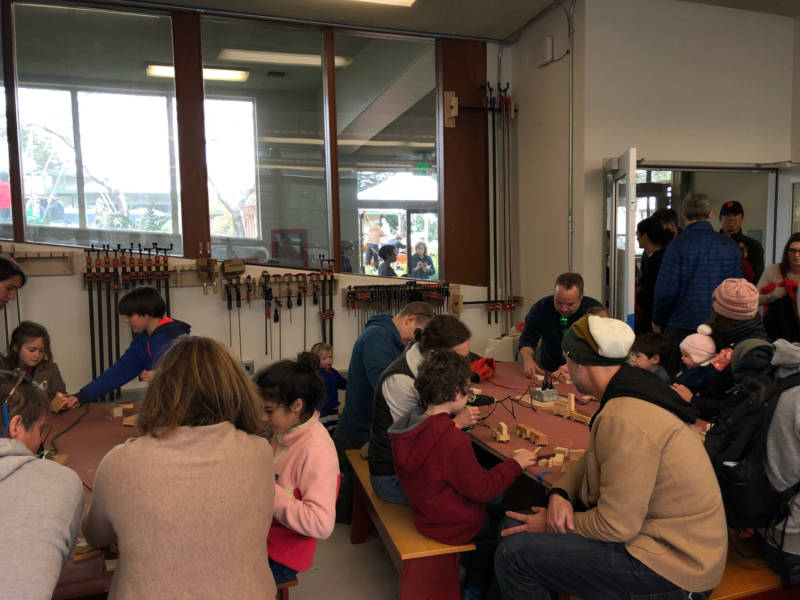 Museumgoers of all ages use hot glue guns to assemble their woodworking projects at the Randall Museum in San Francisco.