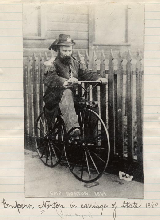 A snarky caption is scrawled below this image of Norton on a bicycle.