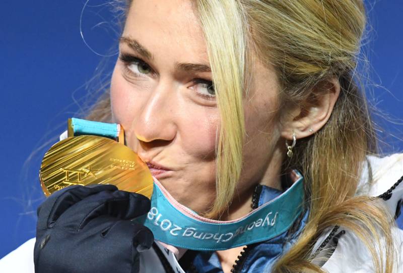 Team USA's Mikaela Shiffrin kisses her gold medal on the podium during the medal ceremony for the women's alpine skiing giant slalom.