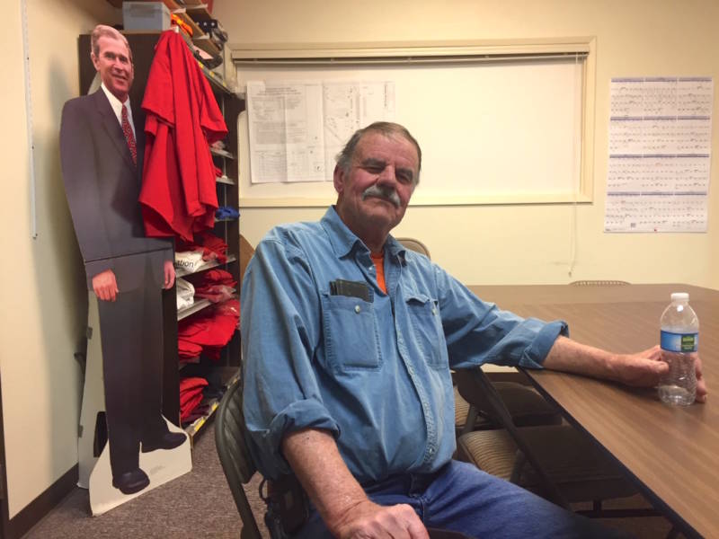 Chuck Bell with the Lucerne Valley Economic Development Association sits in a conference room above the town's only grocery store, where the owners still display a cardboard cutout of George W. Bush. Bell supports expanding mining in the California desert.