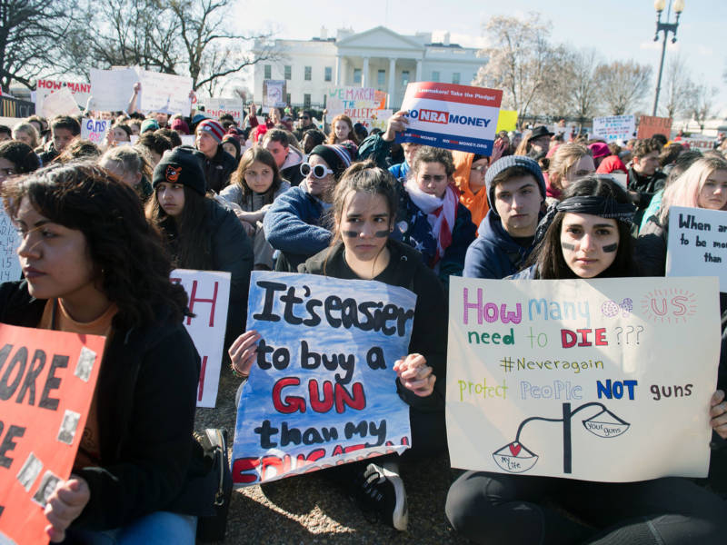 Thousands of local students sit for 17 minutes in honor of the 17 students killed last month in a high school shooting in Florida, during a nationwide student walkout for gun control in front the White House in Washington, D.C.