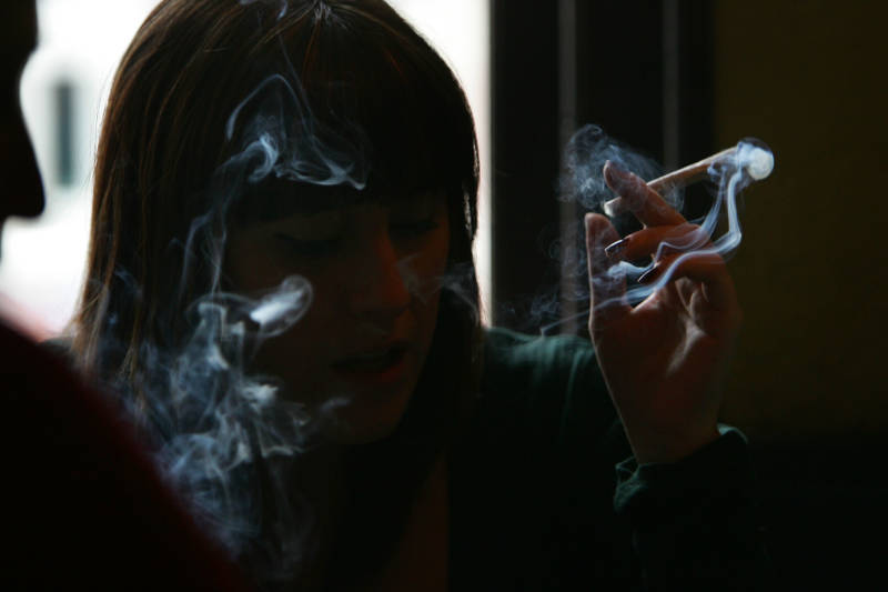 A woman smokes a cigarette of marijuana in an Amsterdam cafe, a model the may soon be seen in San Francisco.