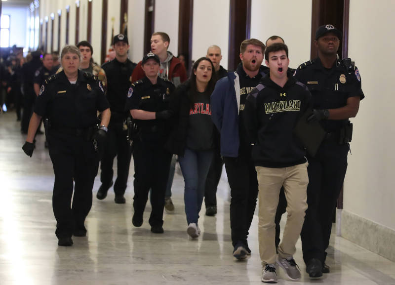 Washington area students are arrested for protesting in front of Senate Majority Leader Mitch McConnell's (R-KY), office to urge Congress into changing gun laws in the wake of the high school massacre in Parkland, Florida last month, on Capitol Hill, March 7, 2018 in Washington, DC.