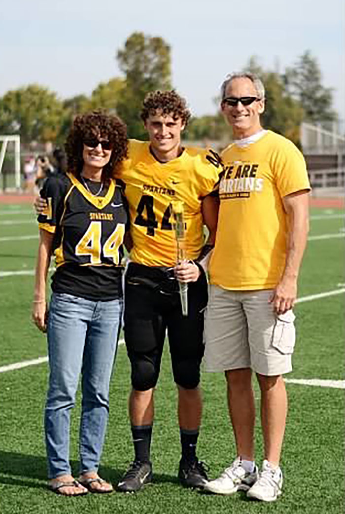 Danny Holton with his mom and dad, Carolyn and John, at a high school football game. 