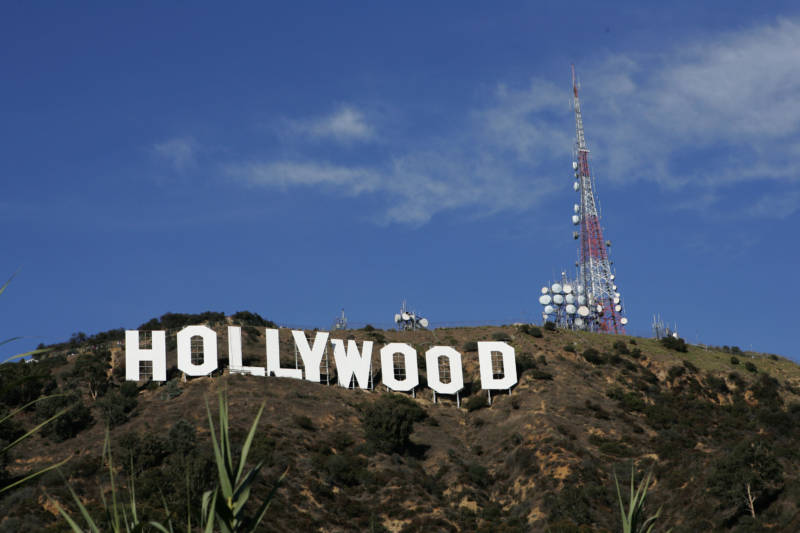 Color photo of the Hollywood sign with blue sky above