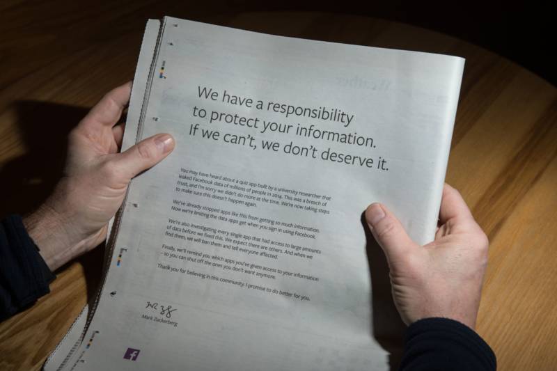 A man reads a full-page advertisment, taken out by Mark Zuckerberg, the chairman and chief executive officer of Facebook to apologize for the large-scale leak of personal data from the social network, on the backpage of a newspaper, in Ripon, England on March 25, 2018. Ads also appeared in the New York Times and Washington Post.