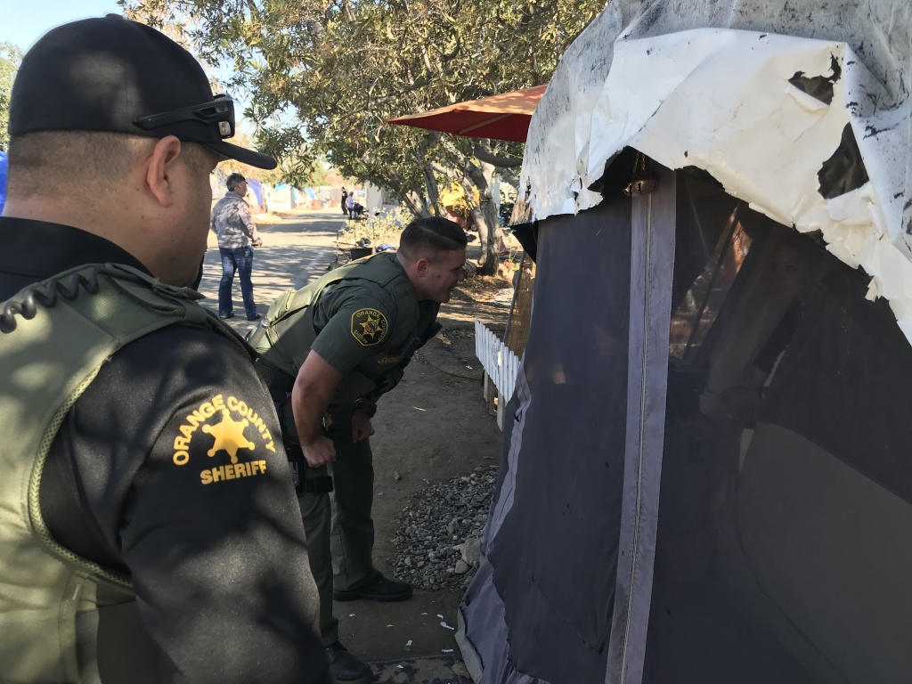 Orange County sheriff's deputies on Monday began going tent to tent along the Santa Ana River telling people the area will be closed and they need to move.