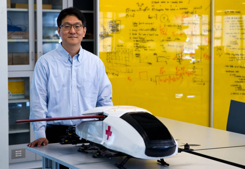 Soon-Jo Chung, associate professor of aerospace at Caltech and a Jet Propulsion Laboratory research scientist, stands behind a scale model of the air ambulance. Its design is modeled on a puffer fish.
