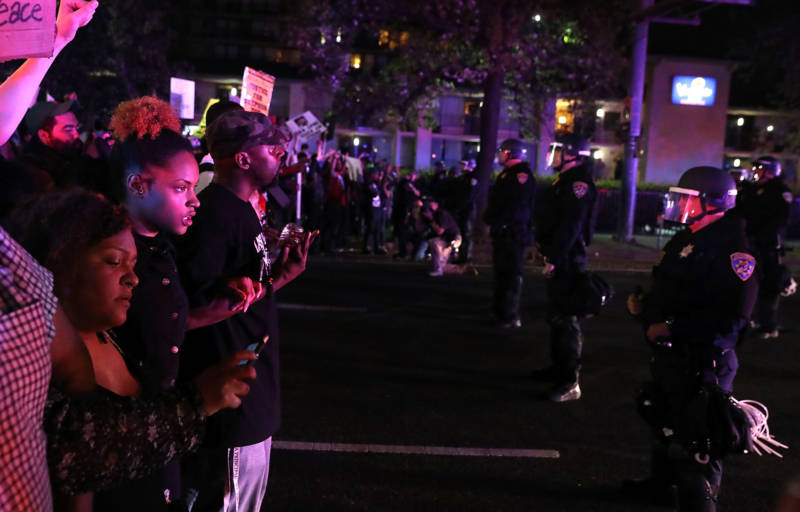 Black Lives Matter protesters confront a line of California Highway Patrol officers during a demonstration on March 30, 2018 in Sacramento.