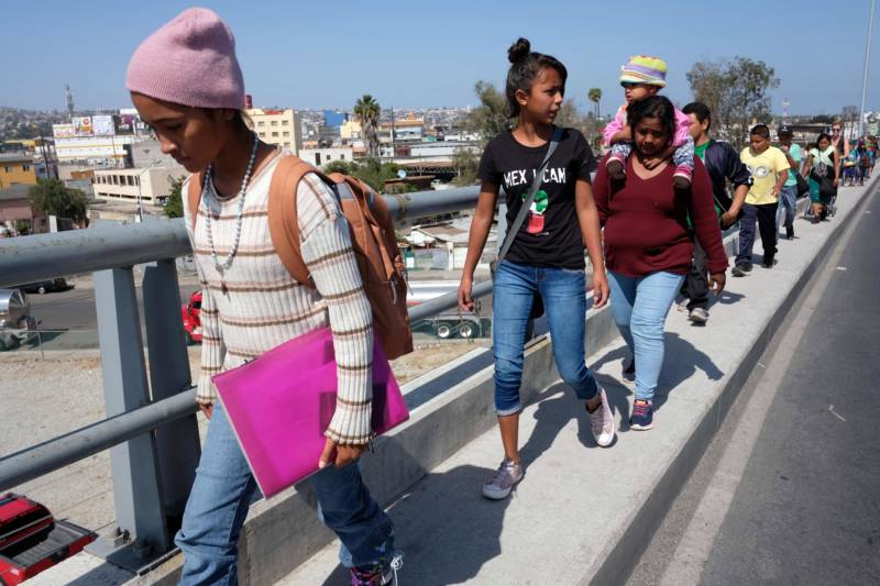 Central American migrants travelling in the "Migrant Via Crucis" caravan walk to their legal counselling meeting in Tijuana, Baja California state, Mexico, on April 28, 2018. The US has threatened to arrest around 100 Central American migrants if they try to sneak in from the US-Mexico border where they have gathered, prompting President Donald Trump to order troop reinforcements on the frontier.