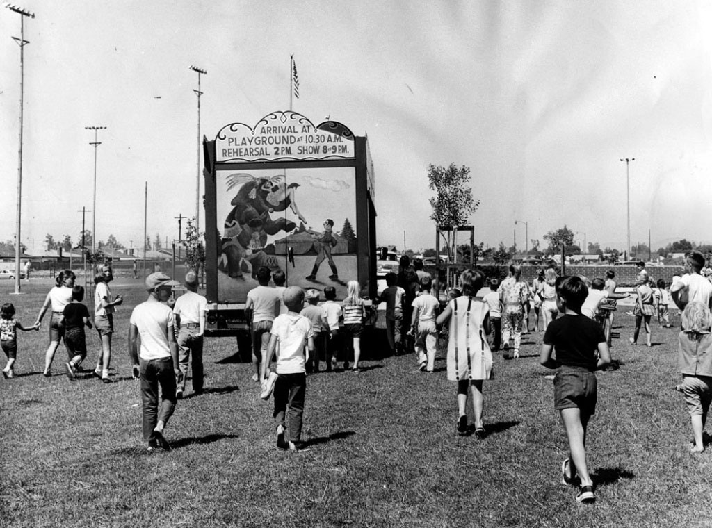 Children follow a truck as it drives into position at Granada Hills Playground to set up the 1964 Combined Traveling Circus and Kiddie Carnival. Photo dated: July 4, 1964.