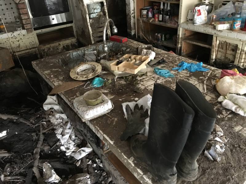 Rubber boots and other mud-caked items sit atop a table in Peri Thompson's kitchen. Hers was one of more than 300 homes damaged by a large mudslide in January that followed the devastating December wildfires in Santa Barbara County.