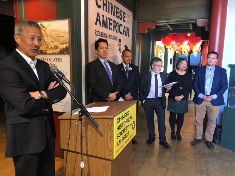 Chinese American Historical Society President Hoyt Zia speaks at a press conference as supervisors and other officials look on.