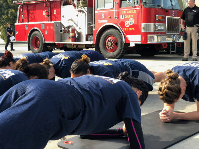 Candidates at the Women's Fire Prep Academy attempt to hold plank position for four minutes.
