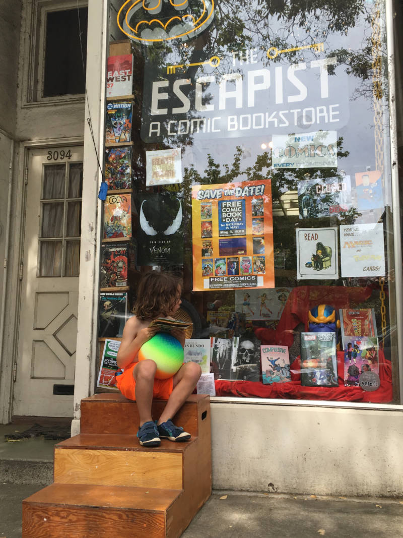 Evan Horn of Berkeley flips through his comics in front of The Escapist Comic Bookstore. He draws his own Captain Underpants comics in his comic drawing class at Park Day school in Temescal.