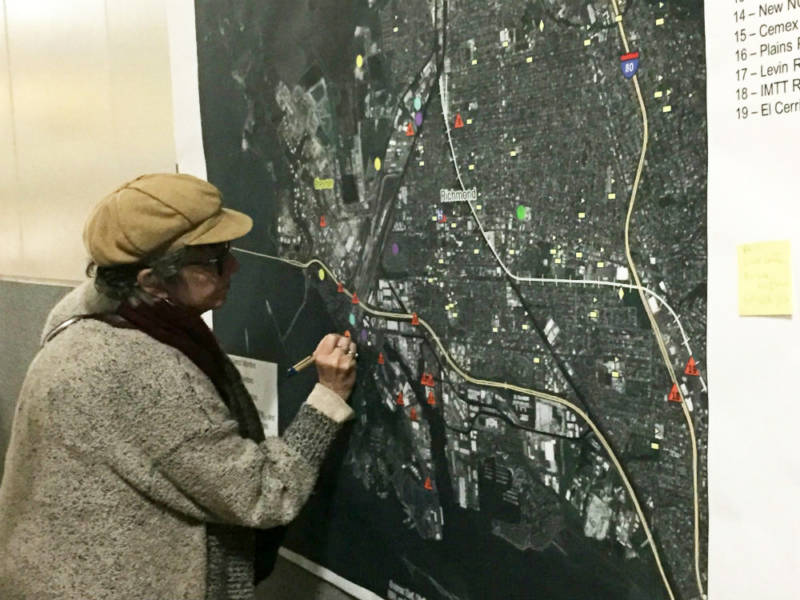 A woman marking up a map for air monitoring.