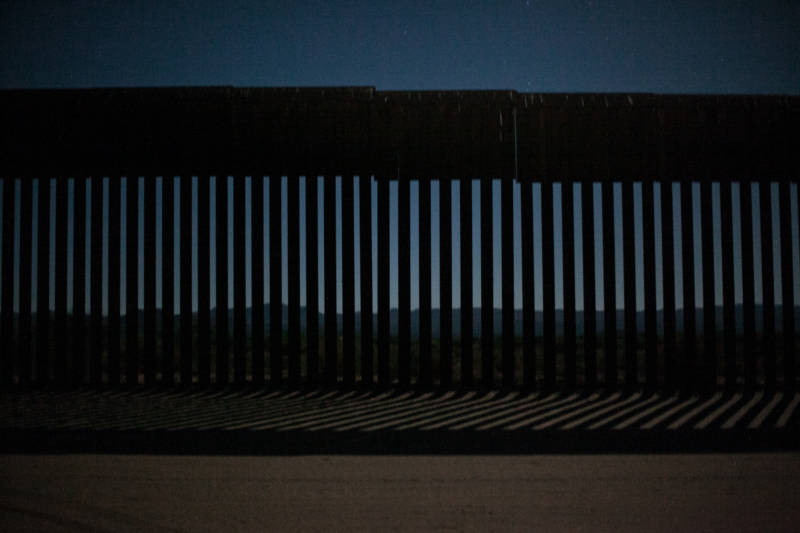 Looking through the metal fence from the U.S. side into Tecate, Mexico on June 28, 2018, before sunrise. The metal fence does not divide the U.S. and Mexico all the way, barbed wire is used as well.