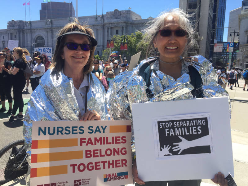Eileen Prendiville (L) and Annie Song-Hill (R) at the San Francisco Families Belong Together march in foil blankets reminiscent of those used by children in detention camps. 'These people are seeking asylum and we need to be humane in the way they’re treated,' Song-Hill says.