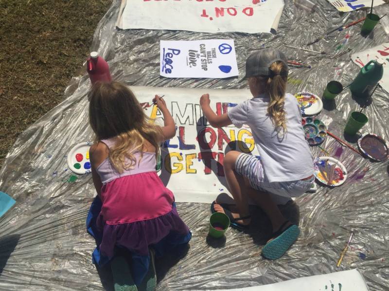 Elodie, age 7, and Jude, age 5, paint signs at the 'Families Belong Together' rally in Oakland.