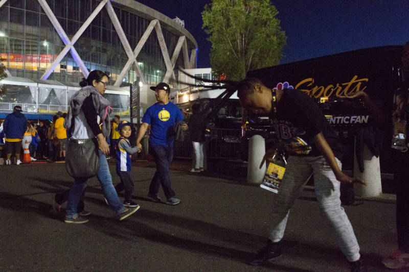 Fans celebrate and dance to 1990s hip-hop throwback hits in the plaza outside of Oracle Arena in Oakland following the Warriors win.